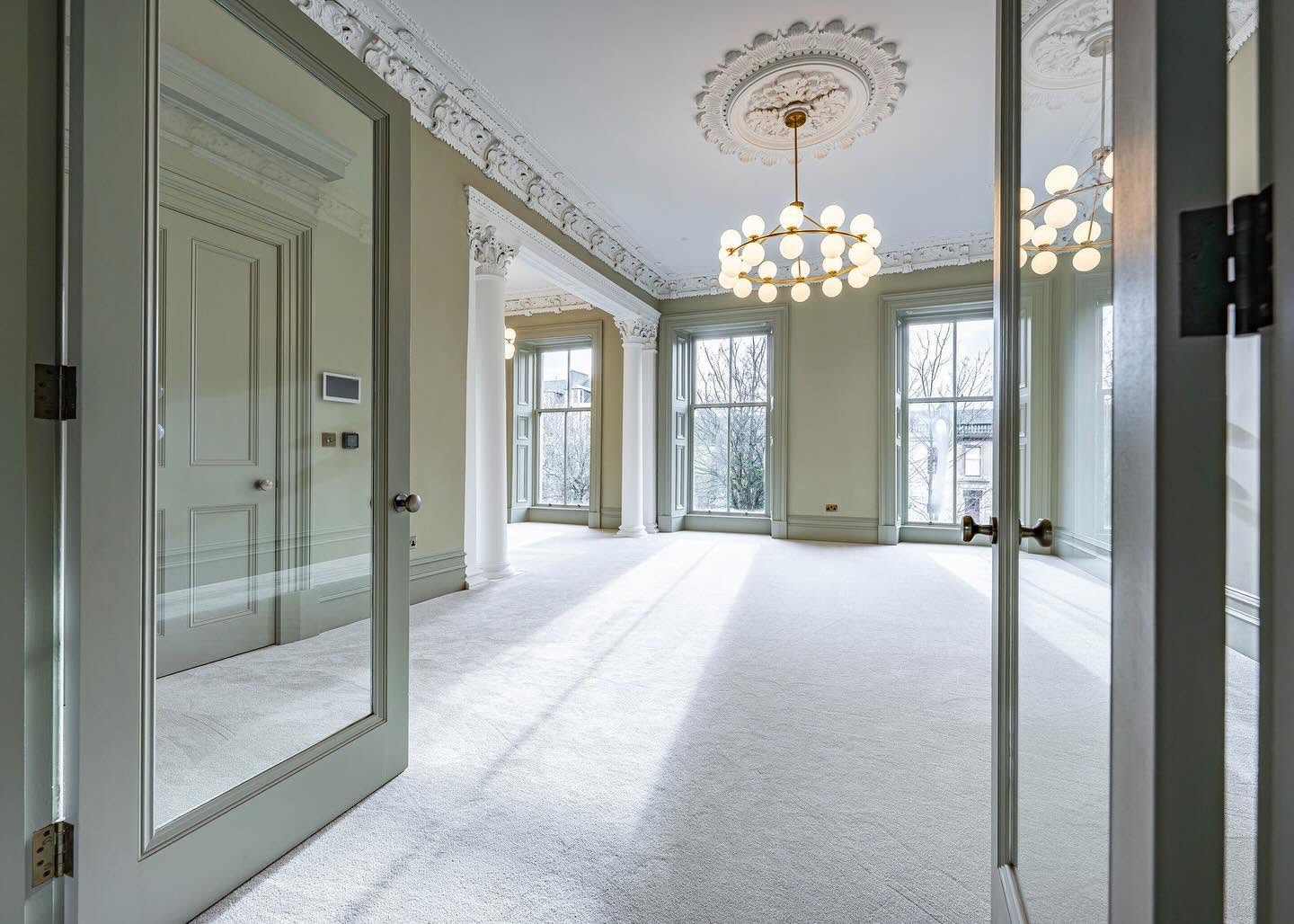 Restored period drawing room with ornate cornice and ceiling rose