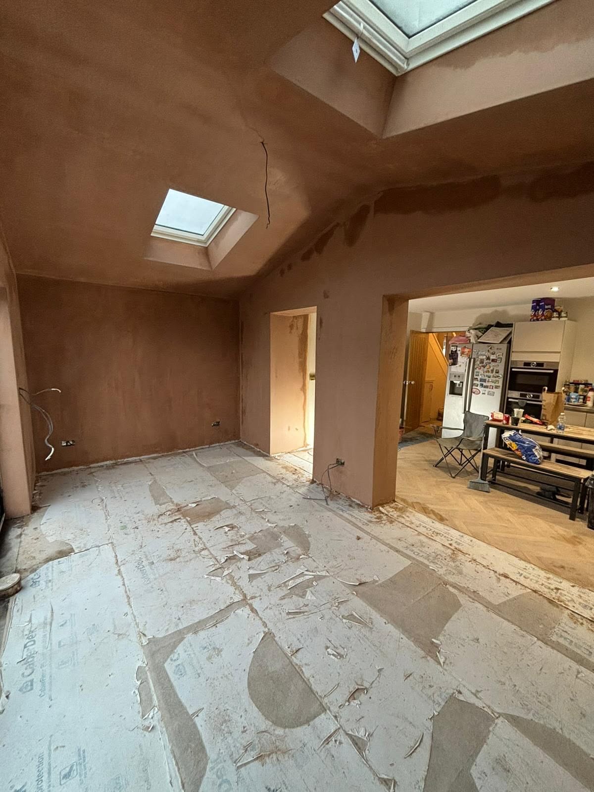 Open-plan room freshly plastered through to the kitchen